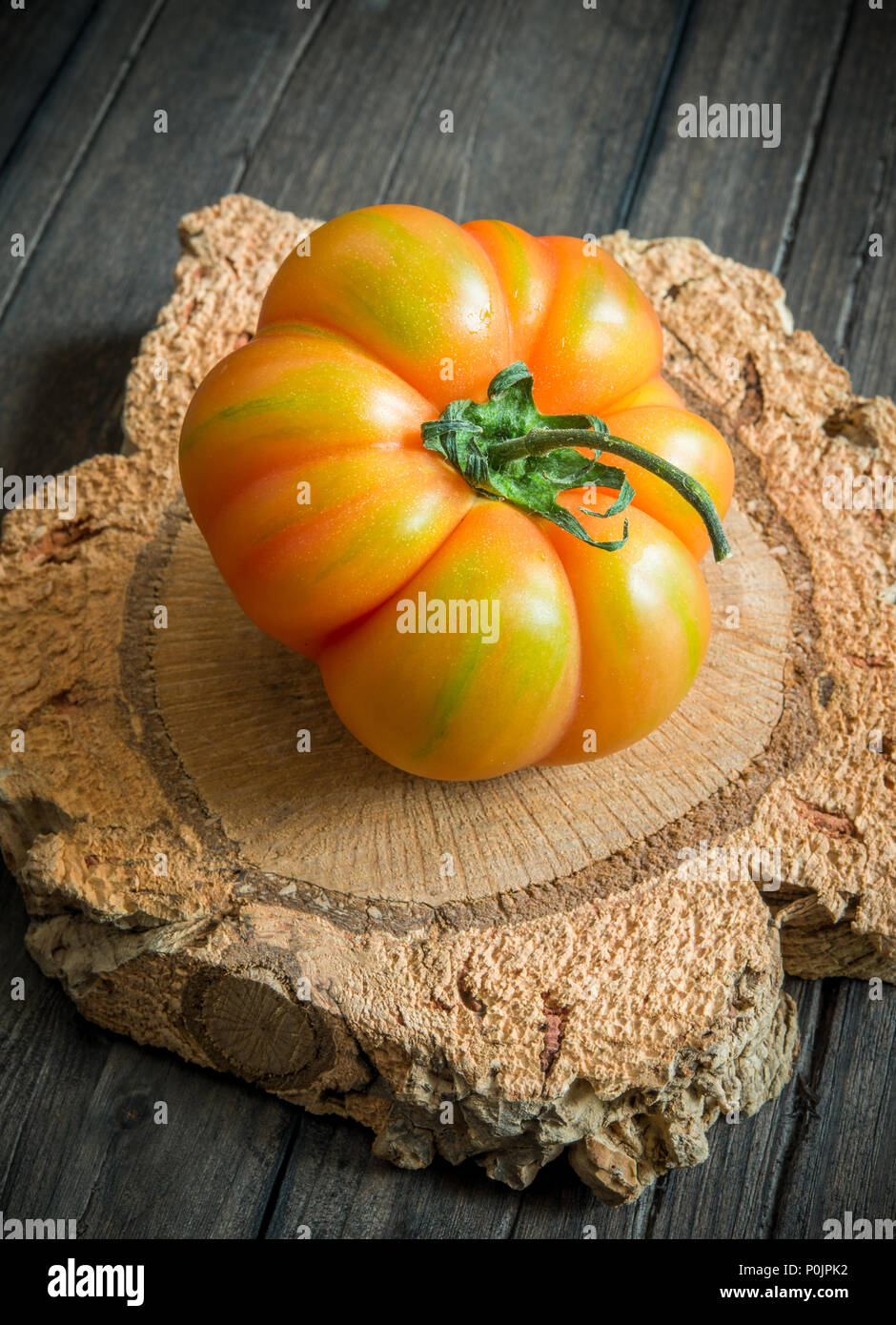 unripe tomato marmande on wooden table Stock Photo