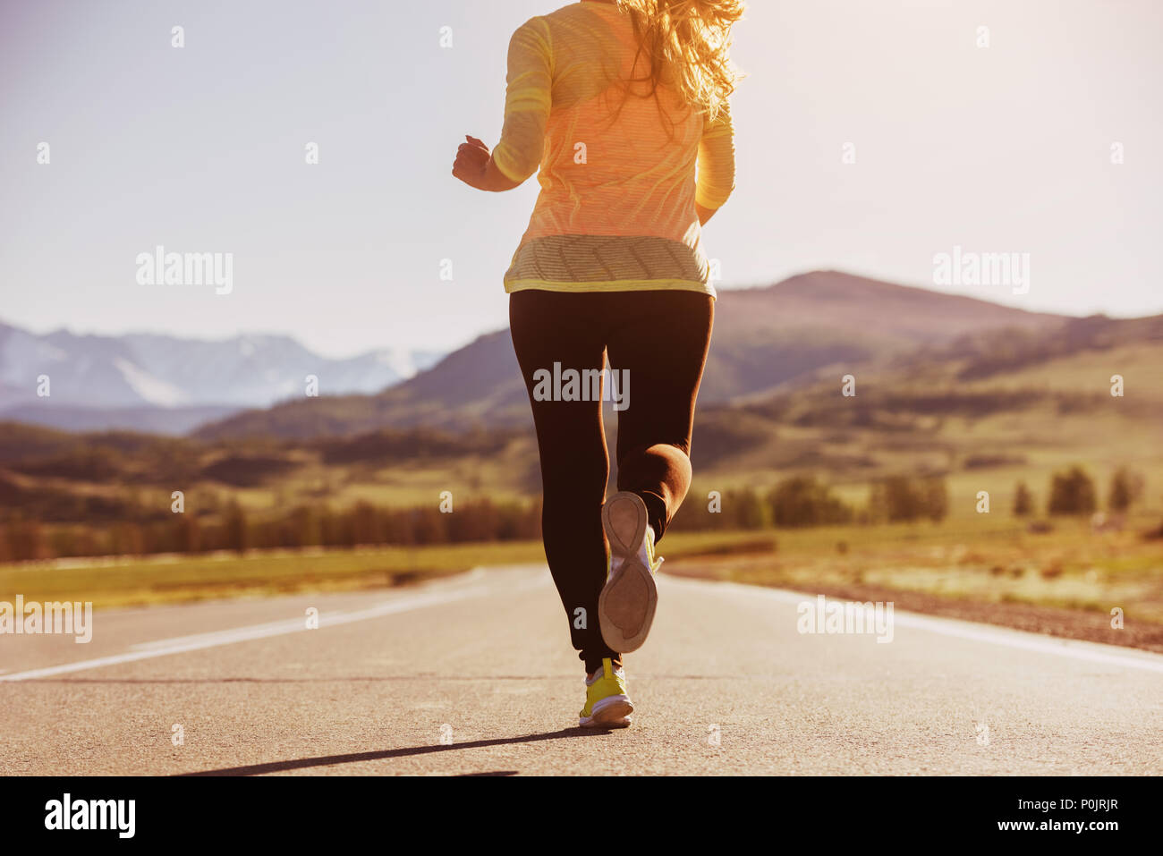 Closeup running woman straight road Stock Photo