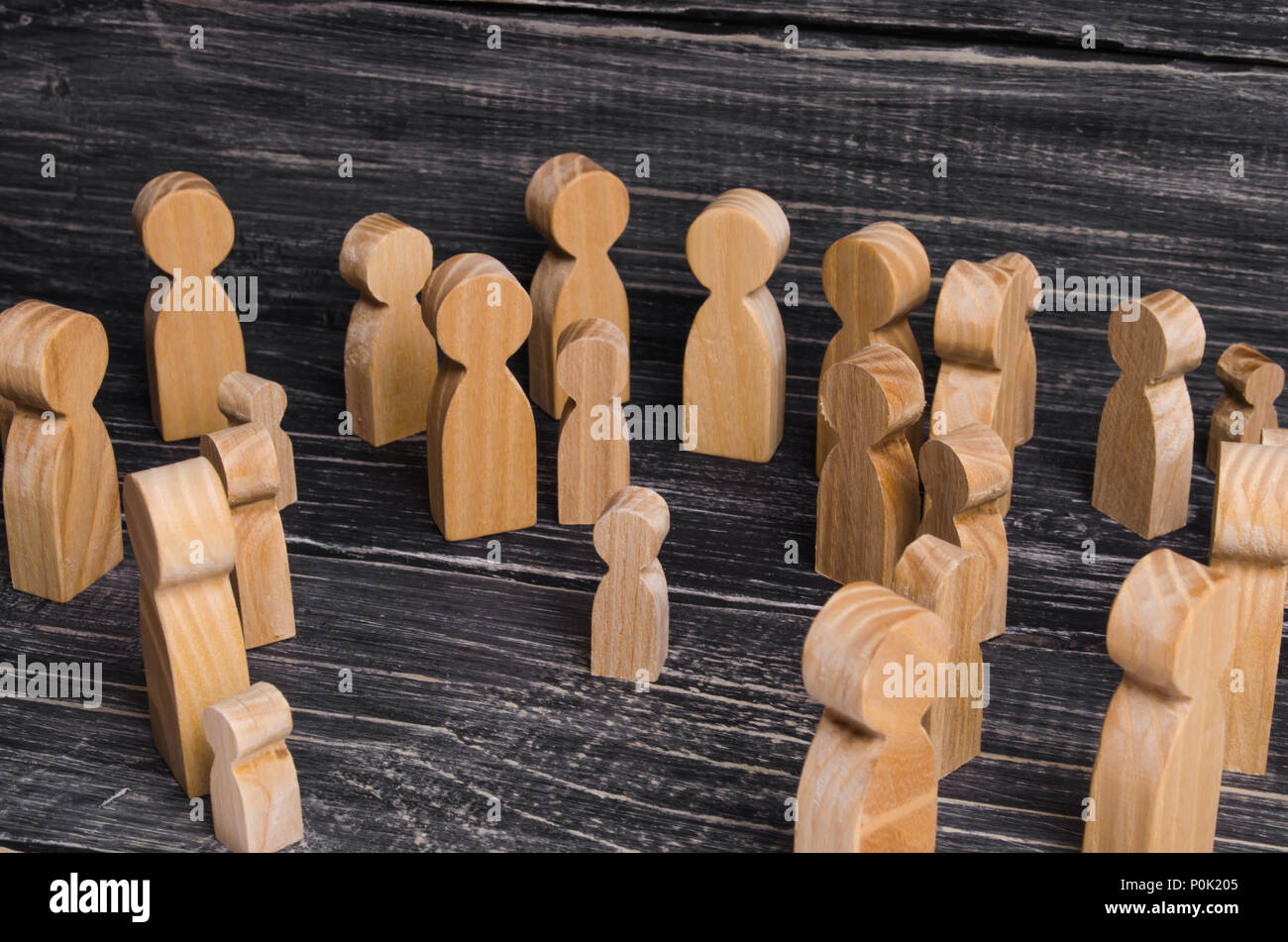 The child was lost in the crowd. A crowd of wooden figures of people surround a lost child. Lost, parents who have lost their parents are a small chil Stock Photo
