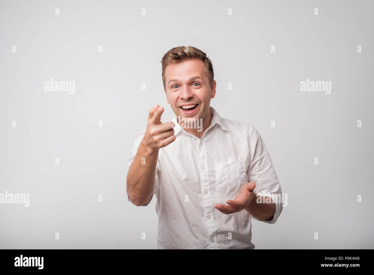Young european man, laughing, pointing with finger at someone, something, isolated on white background. Stock Photo