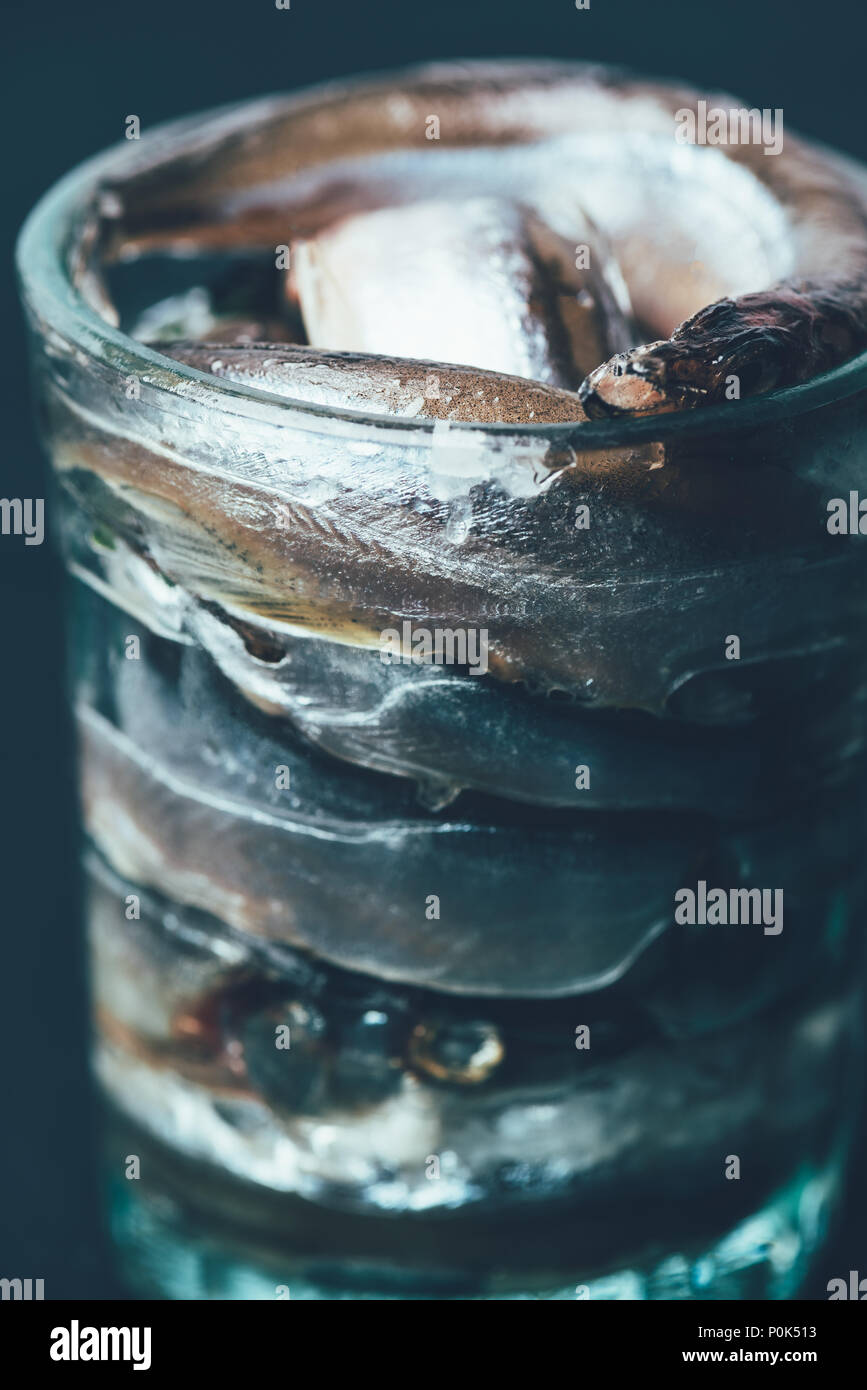 Close up of pile of salted fish in glass isolated on black Stock Photo