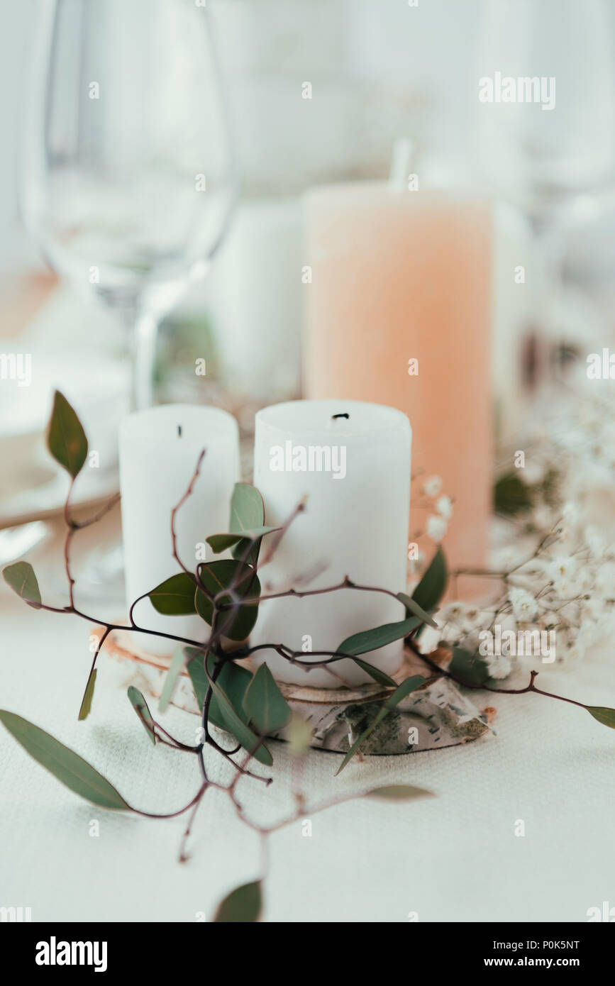 close up view of stylish table setting with candles, flowers and eucalyptus for rustic wedding Stock Photo