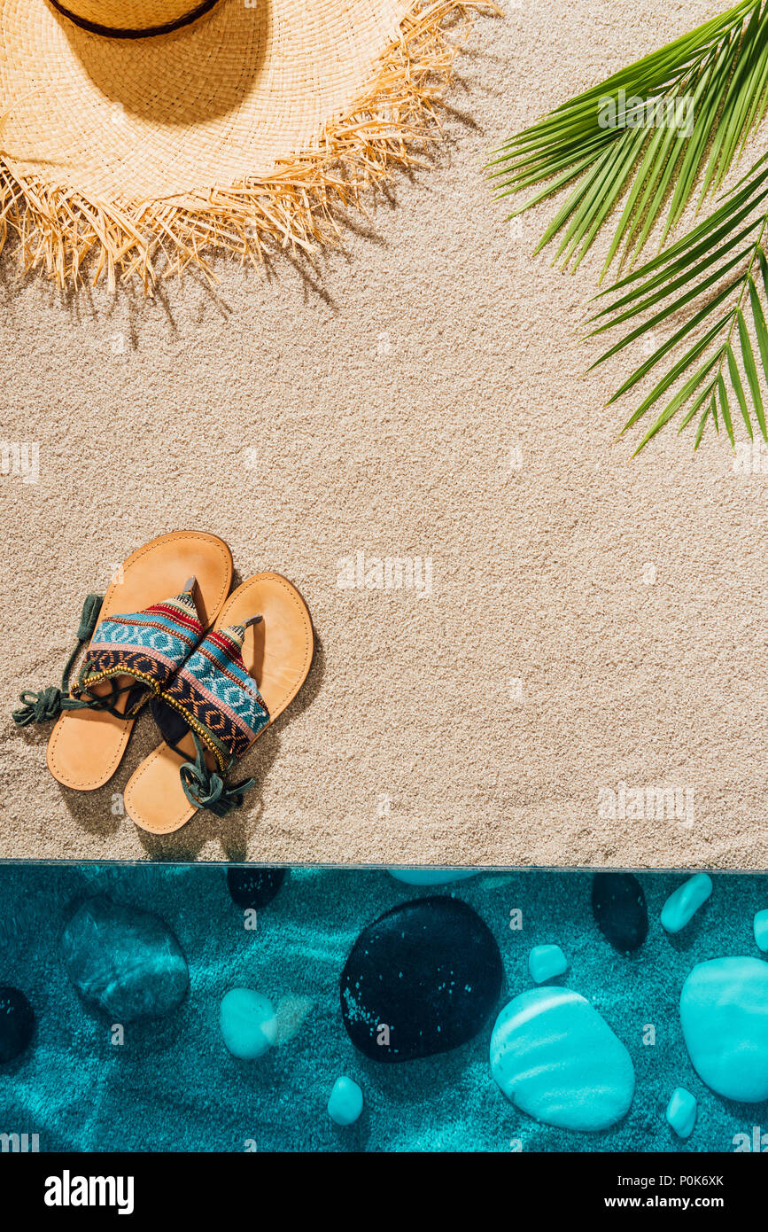 top view of stylish flip flops and straw hat on sandy beach Stock Photo ...