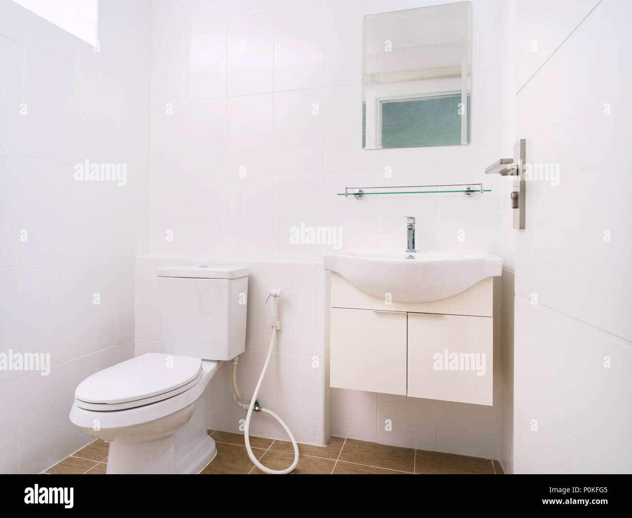 Clean restroom with white toilet, washbasin and mirror decoration with