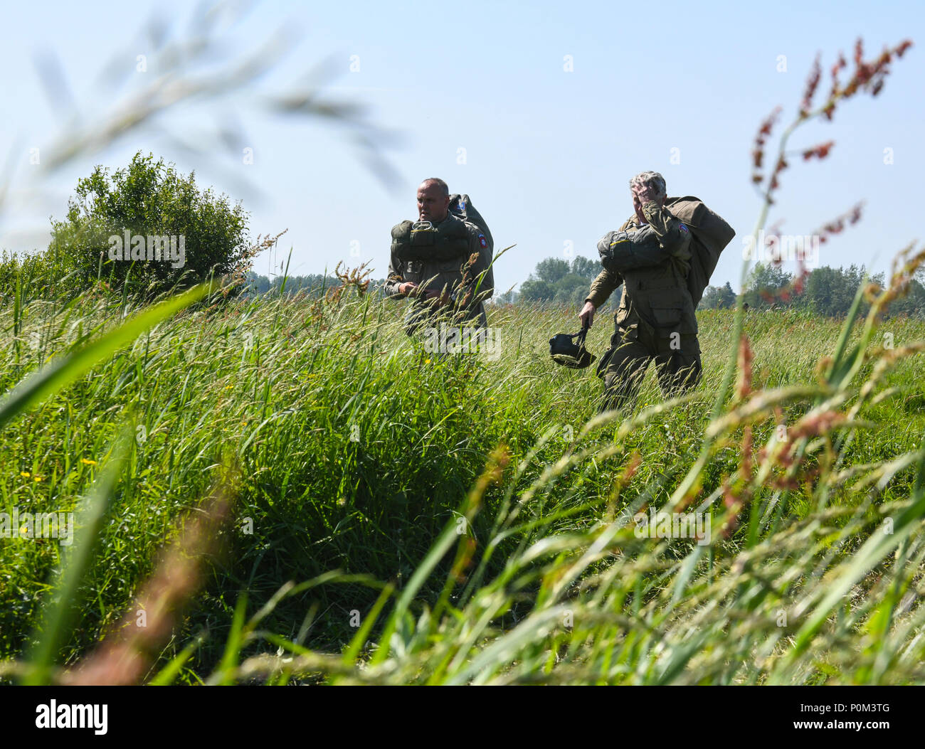 Paratroopers walk through thick brushes of grass from the landing zone June  3 after completing the D-Day 74 airborne operation near  Sainte-Mere-Elglise, France. This year marks the 74th anniversary of  Operation Overlord,