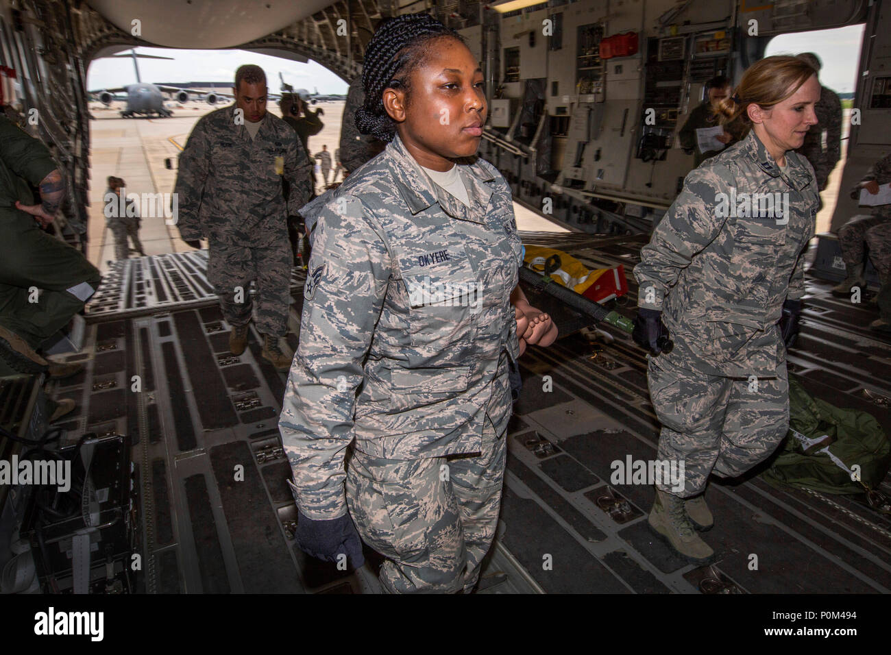 U.S. Air Force Senior Airman Selina N. Okyere, center, 514th Aeromedical Evacuation Squadron, and Capt. Kelly M. Wanamaker, 514th Aeromedical Staging Squadron, both with the 514th Air Mobility Wing, participate in a patient loading exercise at Joint Base McGuire-Dix-Lakehurst, N.J., June 2, 2018. The 514th is an Air Force Reserve Command unit. (U.S. Air Force photo by Master Sgt. Mark C. Olsen) Stock Photo