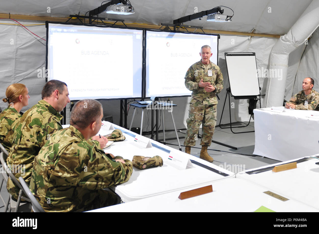 Col. Guy Reedy, chief of staff, 184th Sustainment Command, briefs allied partners on the commands operations during a recent visit to its Tactical Operations Center 4 Jun, Powidz, Poland. 184th SC provides forward mission command overseeing logistics and movements during Saber Strike 18. Host and participating nations benefit from cooperative training opportunities, and we plan to continue these efforts with future Saber Strike exercises. (Mississippi National Guard photo by Staff Sgt. Veronica McNabb, 184th Sustainment Command Public Affairs) Stock Photo