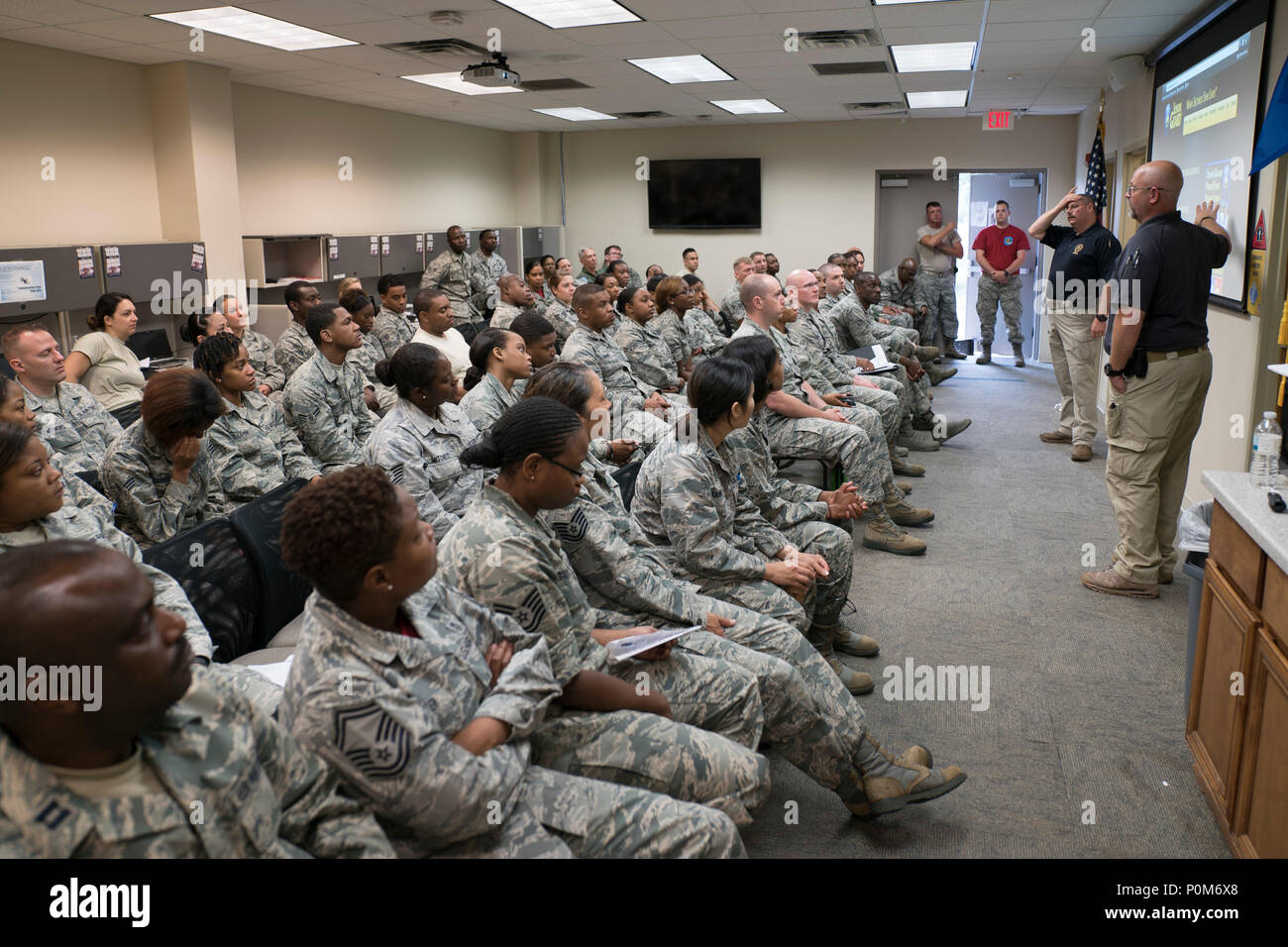 Specialized Parole Officer Phil Burrell, far right, and Police Col. Chris Owens discuss active shooter response methods with Reserve Citizen Airmen of the 413th Aeromedical Staging Squadron June 2, 2018, at Robins Air Force Base, Georgia. Burrell and Owens are Georgia law enforcement officers who visited the military unit to share knowledge on surviving and responding to active shooter events. (U.S. Air Force photo by Jamal D. Sutter) Stock Photo