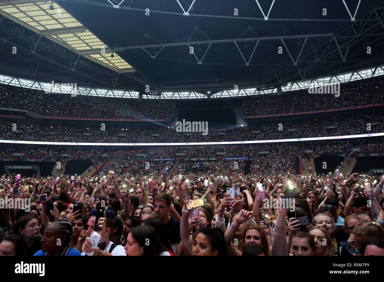 Fans in the crowd hold up their mobiles with the torches turned on during Capital's Summertime Ball with Vodafone at Wembley Stadium, London. PRESS ASSOCIATION Photo. This summer's hottest artists performed live for 80,000 Capital listeners at Wembley Stadium at the UK's biggest summer party. Performers included Camila Cabello, Shawn Mendes, Rita Ora, Charlie Puth, Jess Glyne, Craig David, Anne-Marie, Rudimental, Sean Paul, Clean Bandit, James Arthur, Sigala, Years & Years, Jax Jones, Raye, Jonas Blue, Mabel, Stefflon Don, Yungen and G-Eazy. Picture date: Saturday June 9, 2018. Photo credit sh Stock Photo