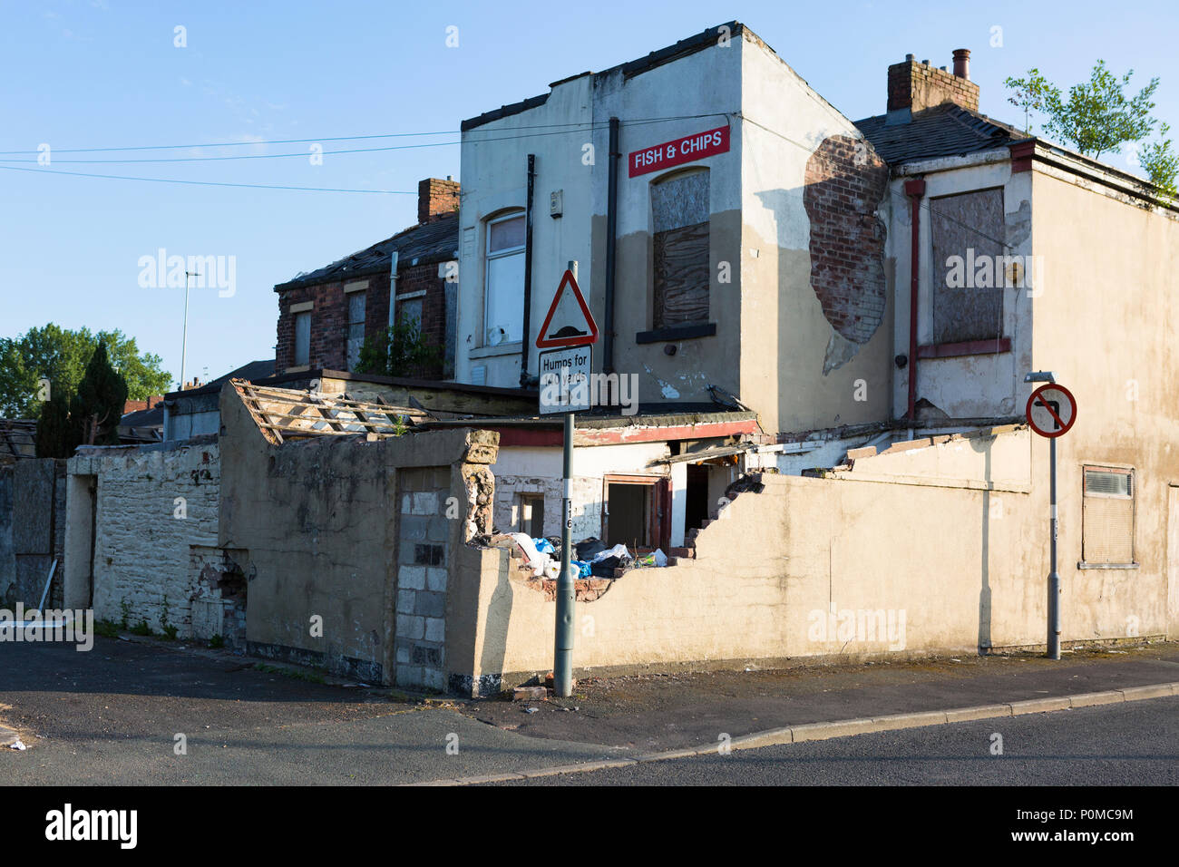 Derelict buildings awaiting demolition in sunset light with a blue sky. Stock Photo
