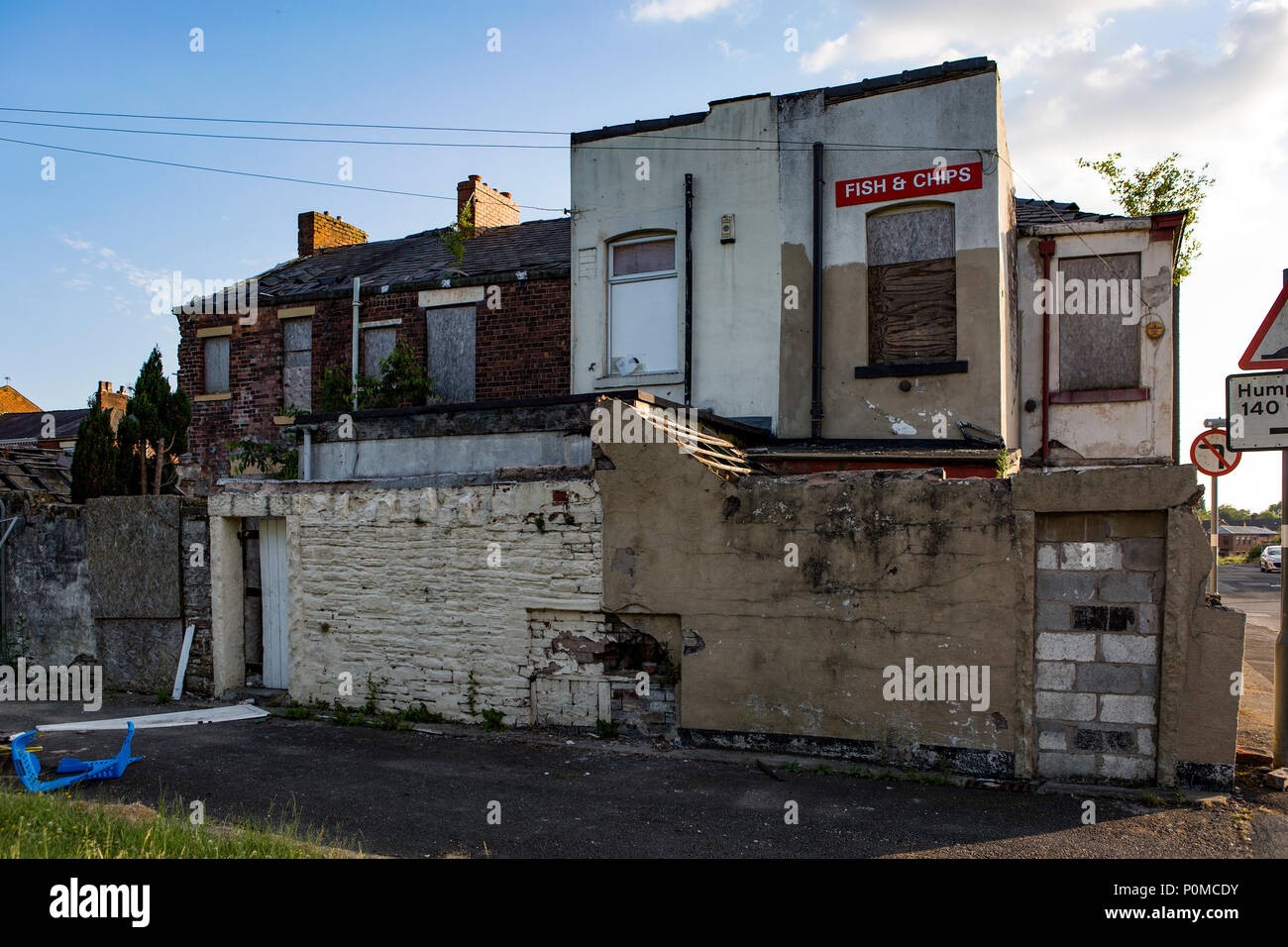 Derelict buildings awaiting demolition in sunset light with a blue sky. Stock Photo