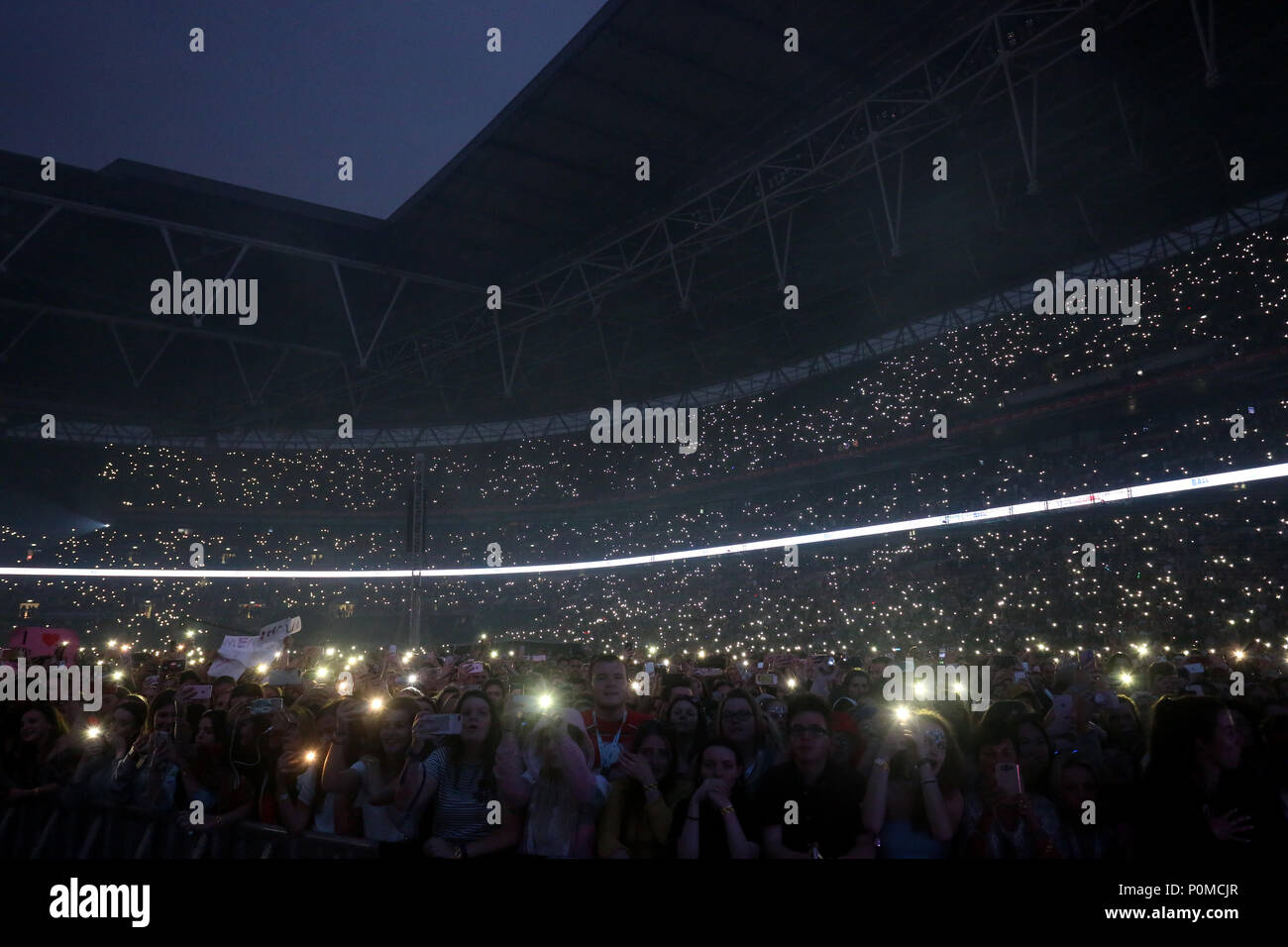 Fans in the crowd hold up their mobiles with the torches turned on during Capital's Summertime Ball with Vodafone at Wembley Stadium, London. PRESS ASSOCIATION Photo. This summer's hottest artists performed live for 80,000 Capital listeners at Wembley Stadium at the UK's biggest summer party. Performers included Camila Cabello, Shawn Mendes, Rita Ora, Charlie Puth, Jess Glyne, Craig David, Anne-Marie, Rudimental, Sean Paul, Clean Bandit, James Arthur, Sigala, Years & Years, Jax Jones, Raye, Jonas Blue, Mabel, Stefflon Don, Yungen and G-Eazy. Picture date: Saturday June 9, 2018. Photo credit sh Stock Photo