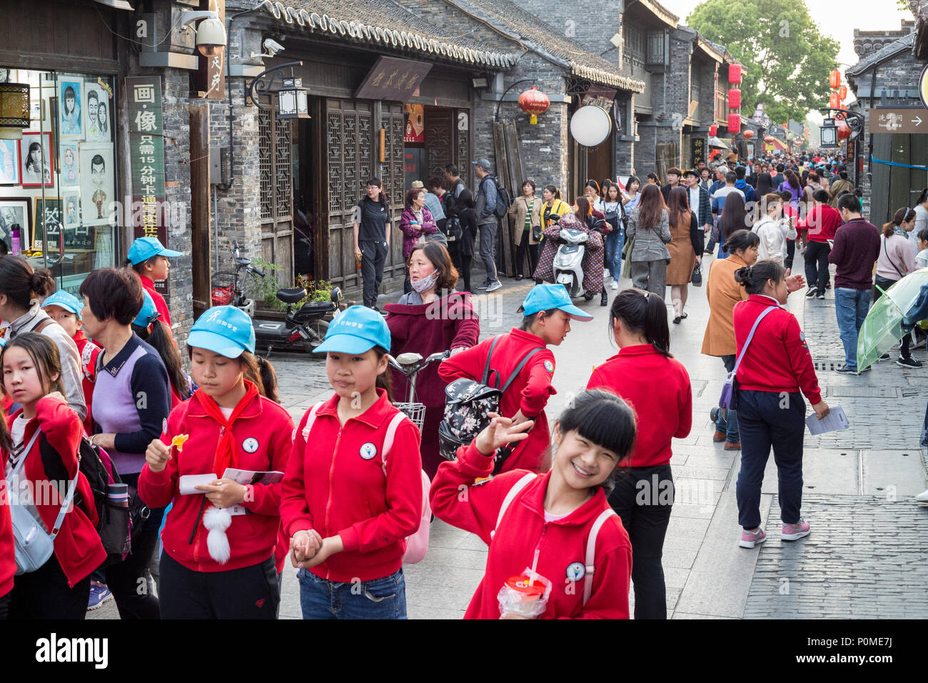 Yangzhou, Jiangsu, China.  Dong Guan Street Scene, Chinese Schoolchildren in Foreground. Stock Photo
