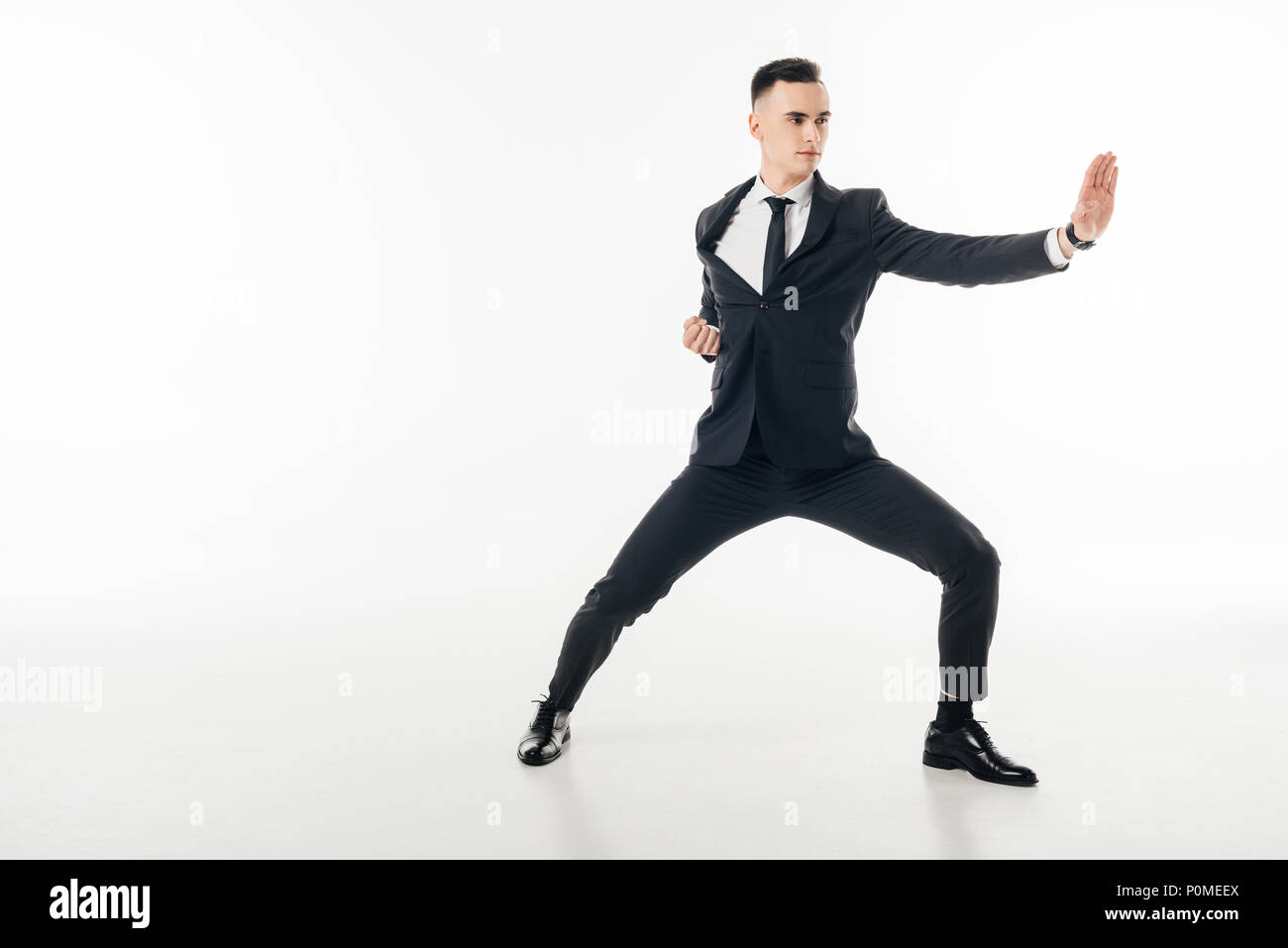 handsome businessman standing in karate position in suit isolated on white Stock Photo