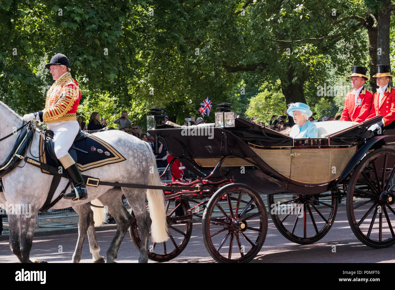 Queen Elizabeth II travels along The Mall in an open carriage pulled by