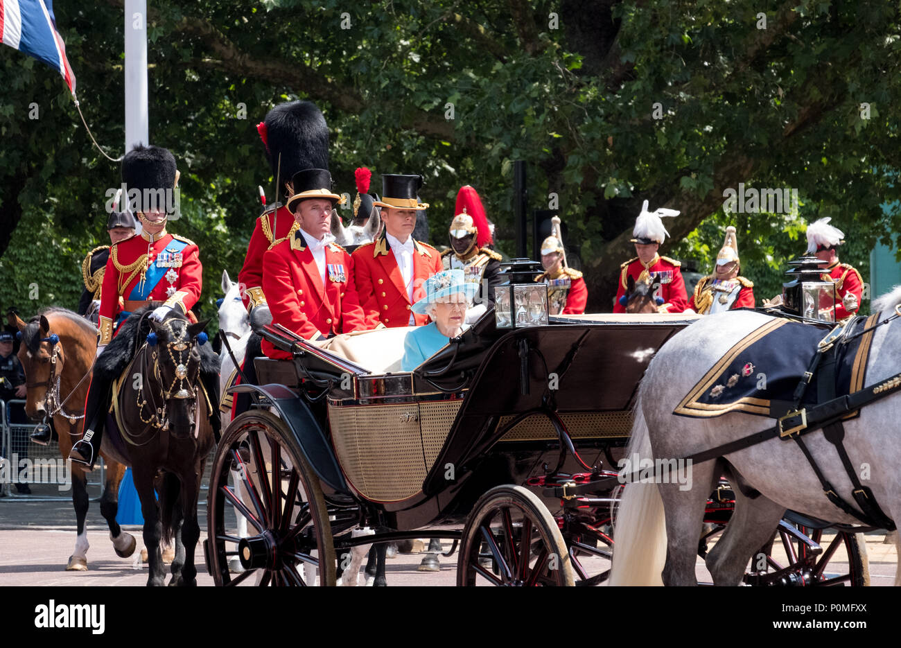 Queen Elizabeth II travels along The Mall in an open carriage pulled by