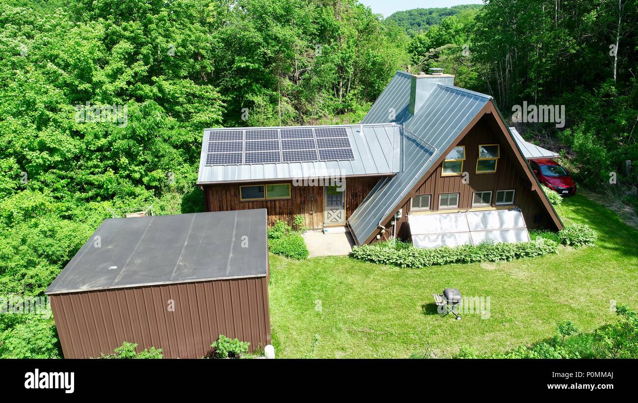 Aerial drone photograph of rural a-frame cabin, completed powered by sun with solar electric system in woods during summer, Hillsboro, Wisconsin, USA Stock Photo