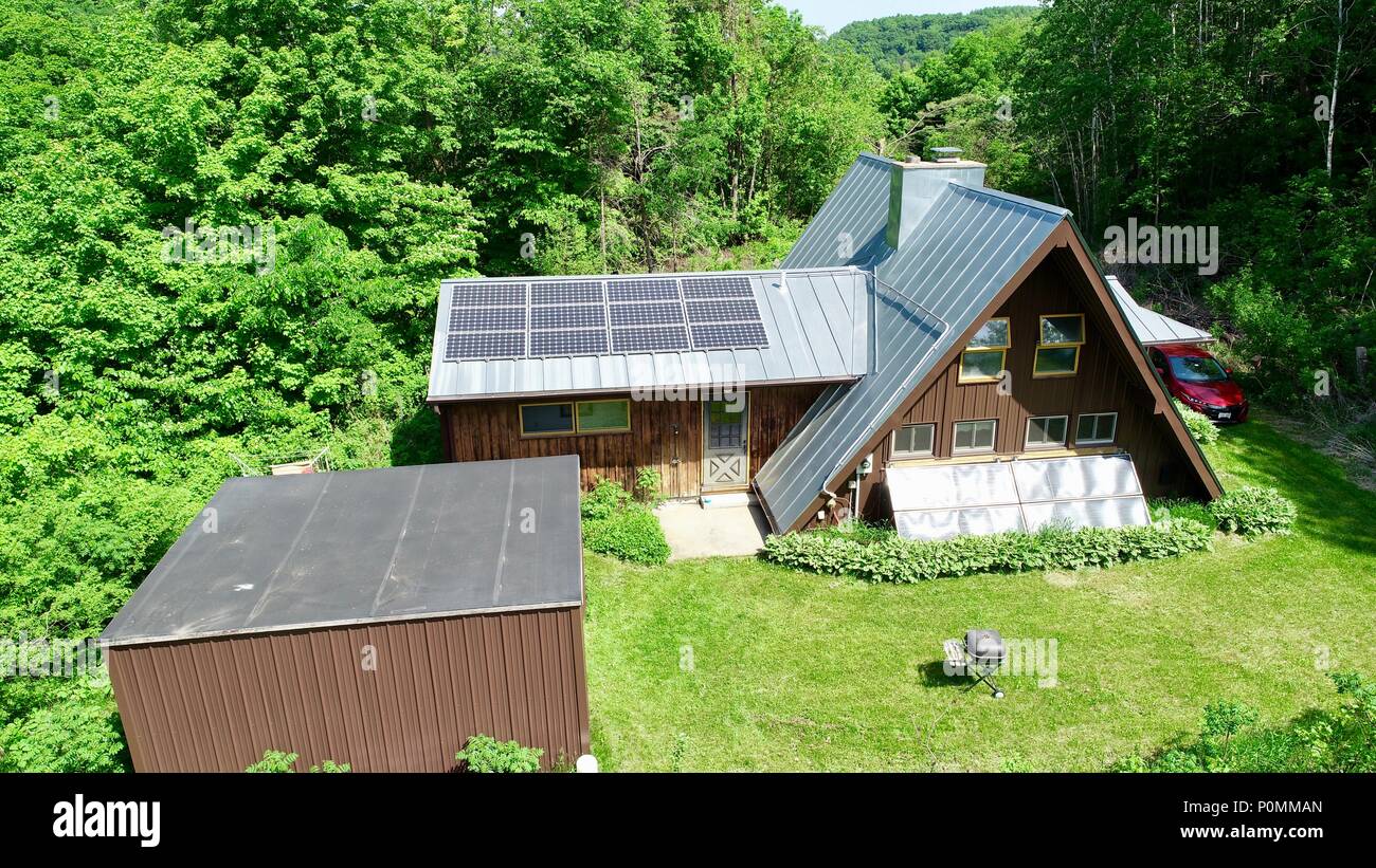 Aerial drone photograph of rural a-frame cabin, completed powered by sun with solar electric system in woods during summer, Hillsboro, Wisconsin, USA Stock Photo