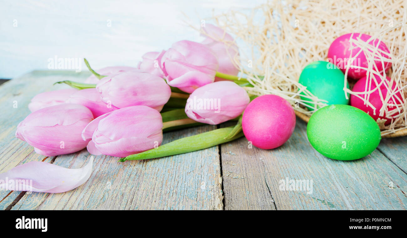 Easter composition with pink tulip flowers, painted Easter eggs and ...