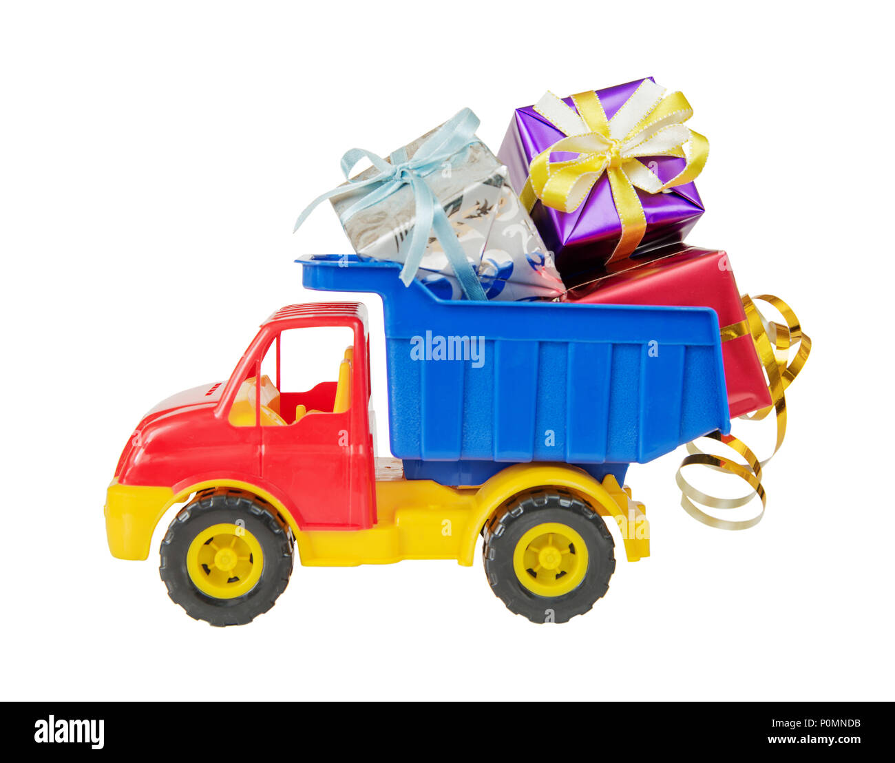 Multicolored plastic toy lorry delivers many gift boxes tied with decorative ribbons in body,  isolated on white background Stock Photo