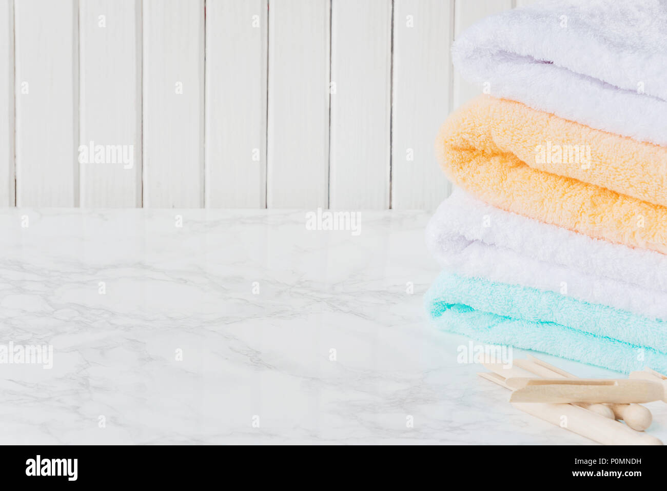 Stack of folded white spa towels over blurred bathroom background