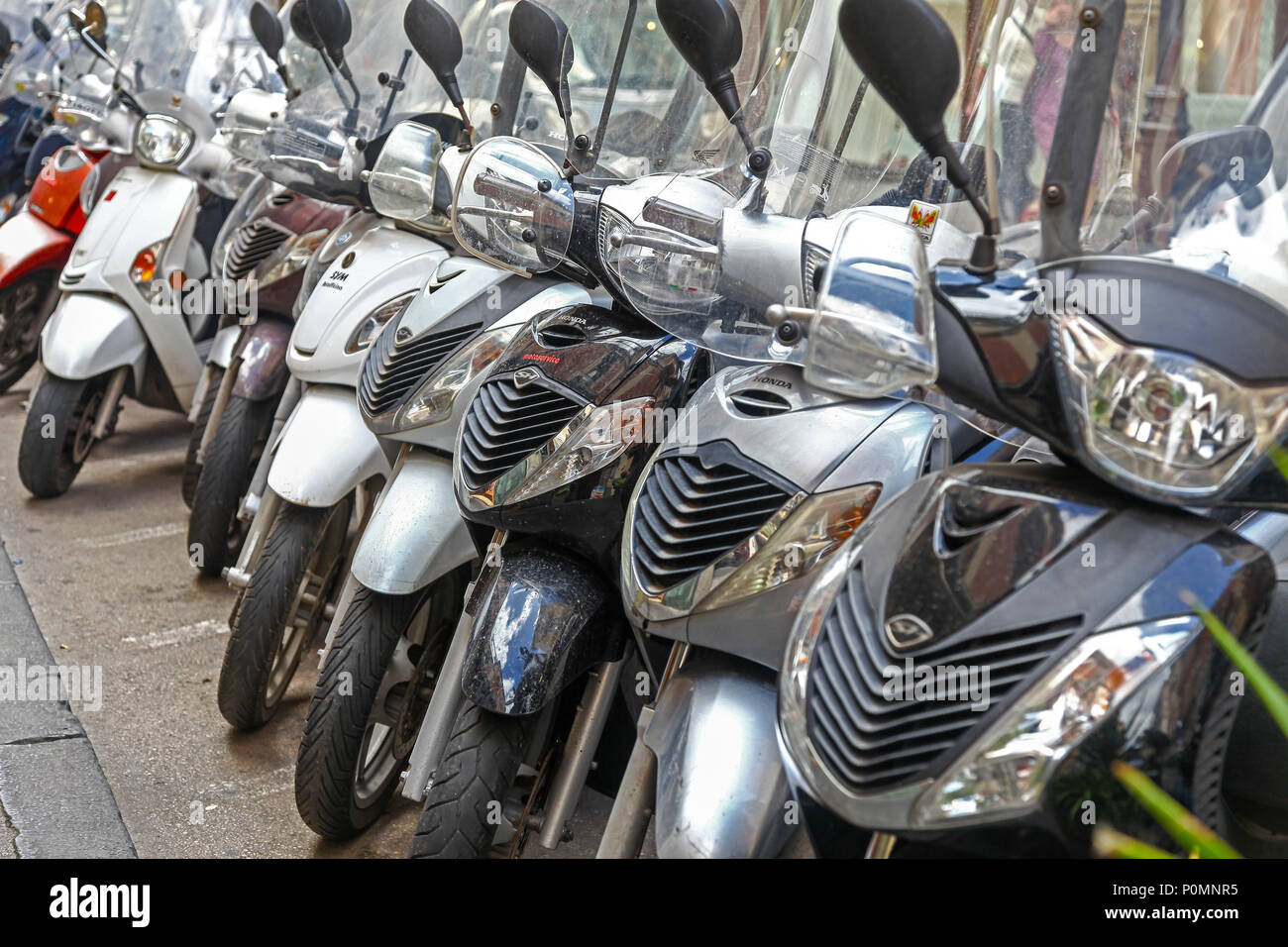 Motorbikes and motor scooters parked in a row in a street in Sorrento, Italy Stock Photo