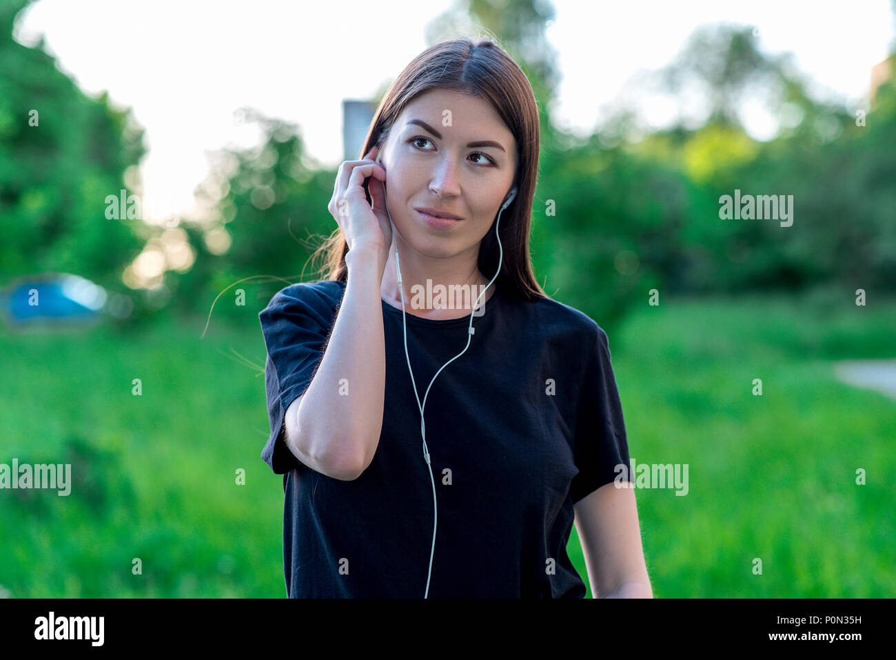 In Summer Park Listen To Music Dressed Casual Clothes The Brunette Dreams Of Good Smiles Thinks Positive Thoughts Voice Headphones On In Summer Park Listen To Music Dressed Casual Clothes The Brunette Dreams Of Good Smiles Thinks Positive Thoughts Voice Headphones On