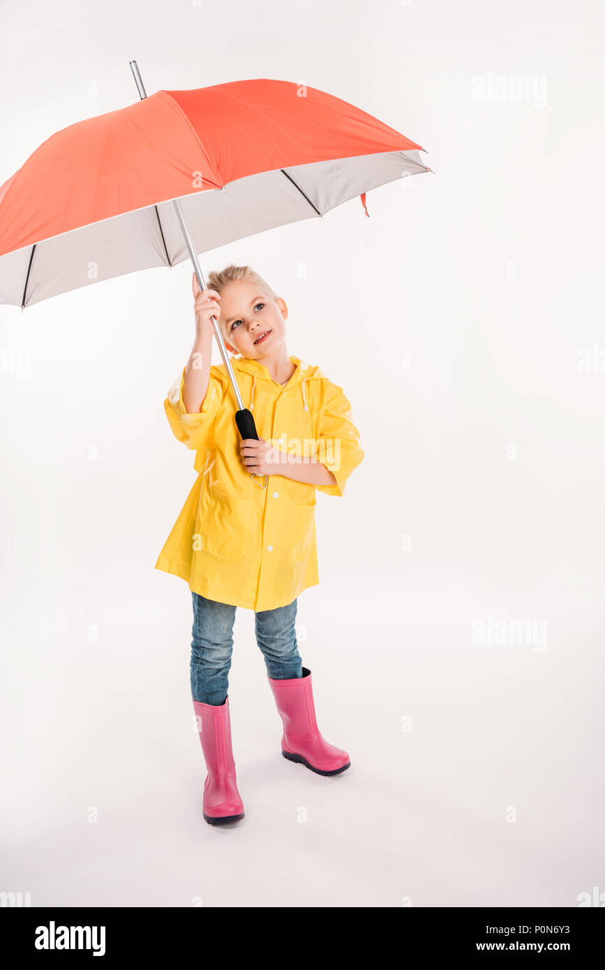 little child in yellow raincoat with umbrella, isolated on white Stock