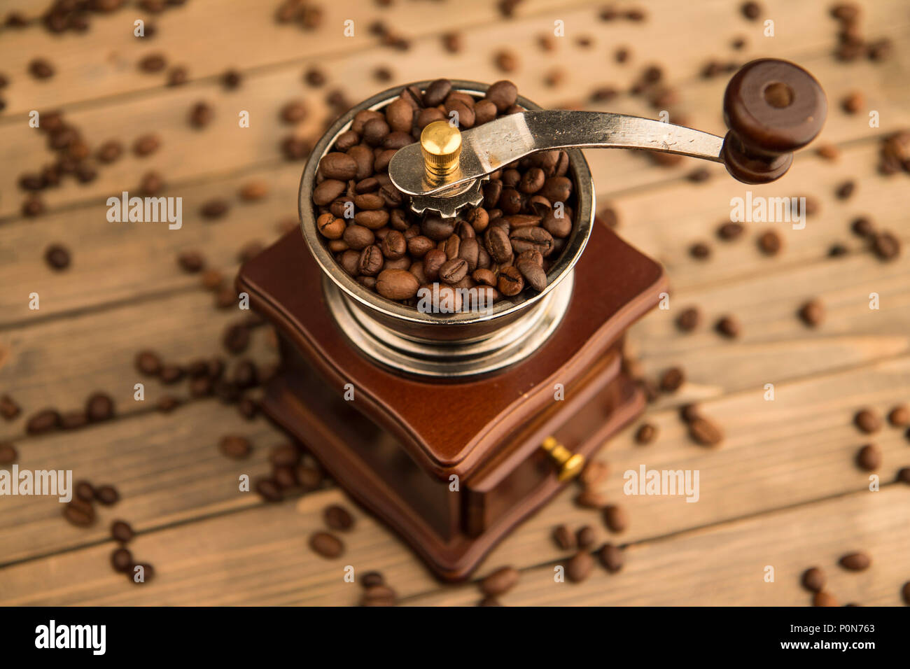 Photo of vintage coffee bean grinder on wooden background background view from above. Stock Photo