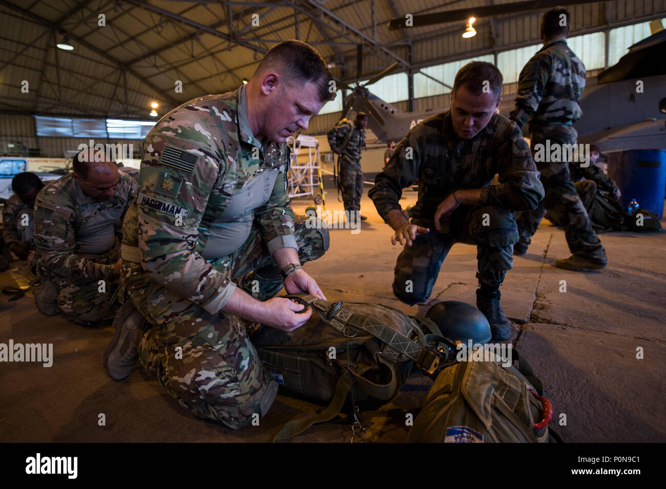 U.S. Army Maj. Matthew Hagerman, left, of the 404th Army Civil Affairs Battalion, receives instruction on his parachute in preparation for the D-Day observation jump near Djibouti-Ambouli International Airport, Djibouti, June 6, 2018. Service members from the French Armed Forces, Camp Lemonnier and Combined Joint Task Force - Horn of Africa participated in the multi-national jump to commemorate the June 6, 1944, allied invasion of Normandy, France, the largest seaborne invasion in history.  (U.S. Air Force photo by Tech. Sgt. Larry E. Reid Jr.) Stock Photo