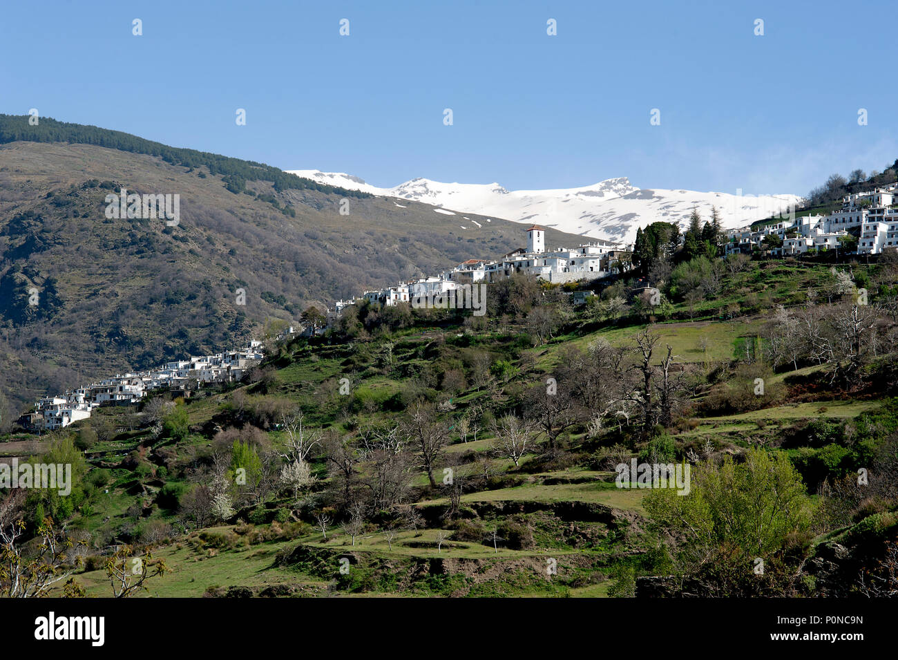 the picturesque Alpujarran village of Capileira in its stunning location high up in the snow-capped Sierra Nevada mountains in Spain's Andalucia. Stock Photo