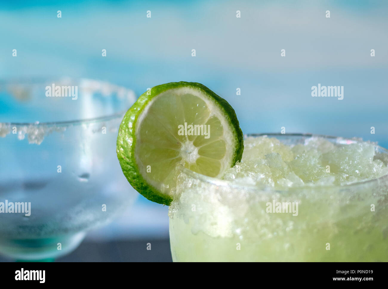 icy frozen margarita drinks with slices of lime Stock Photo - Alamy