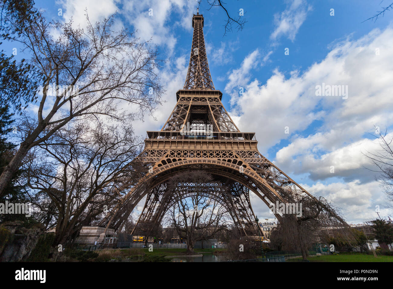 Wide angle view of iconic Eiffel tower with dramatic cloudy blue sky in the background. Stock Photo