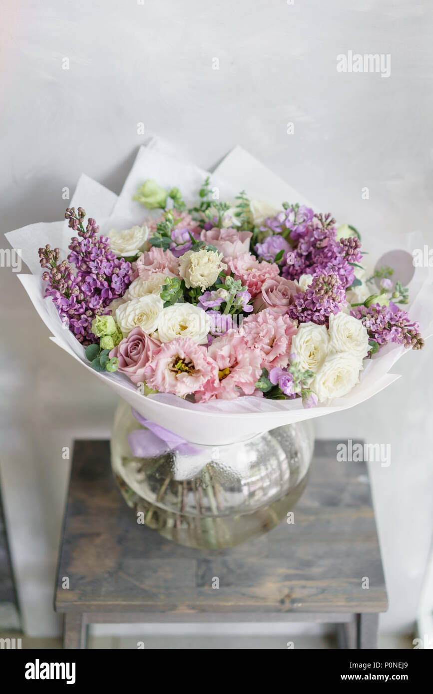 Floristry concept. Bouquet of beautiful flowers on gray table. Spring colors. the work of the florist at a flower shop. Stock Photo