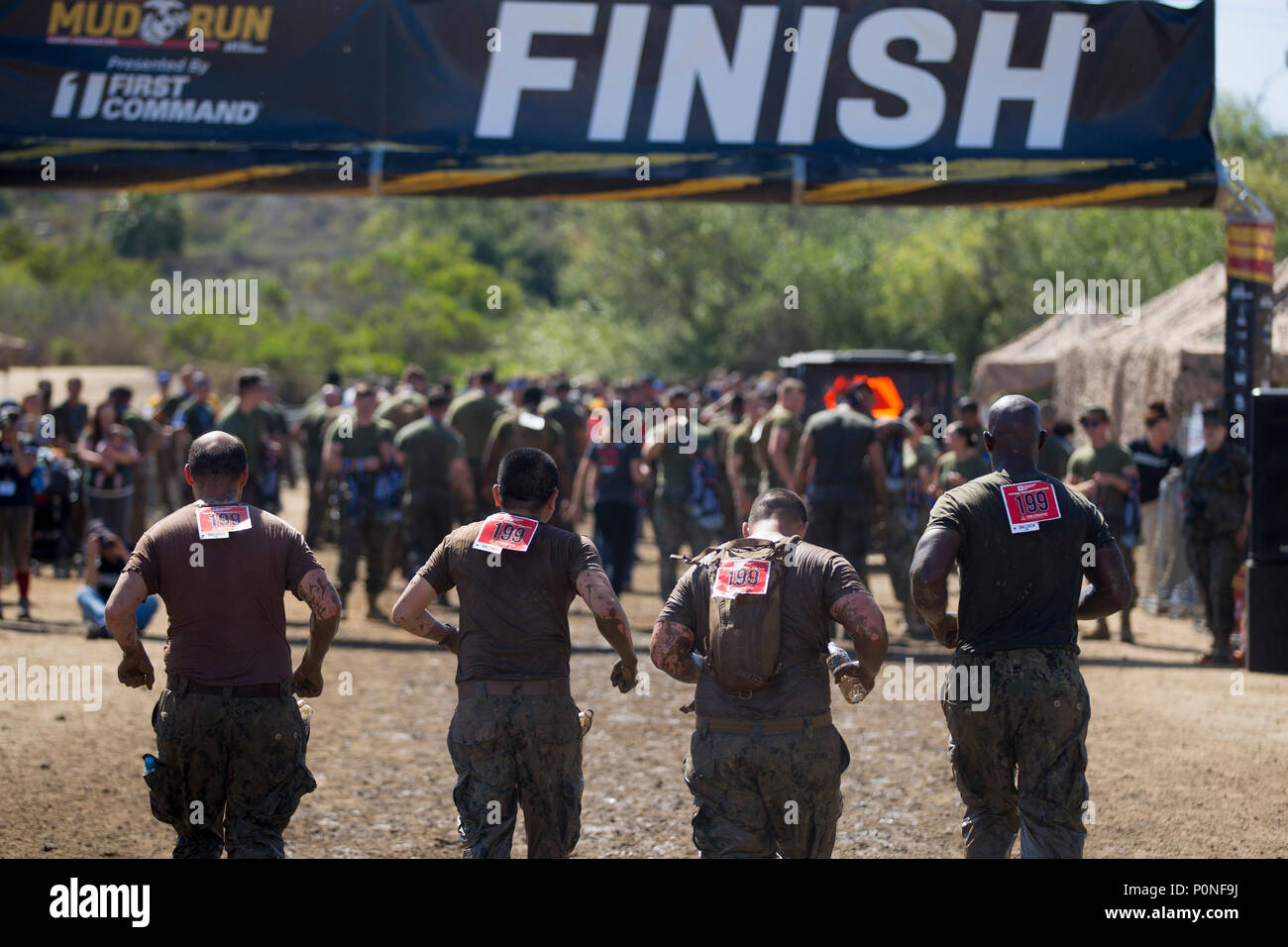Sailors run towards the finish line of the 2018 Mud Run Commanding General’s Cup Team Competition, on Marine Corps Base Camp Pendleton, Calif., June 8, 2018. The race stretched over 10-kilometers around Lake O’Neill on MCB Camp Pendleton. Over 2,000 Marines from numerous units around California and neighboring states participated in the challenge. (U.S. Marine Corps photo by Cpl. Juan C. Bustos) Stock Photo