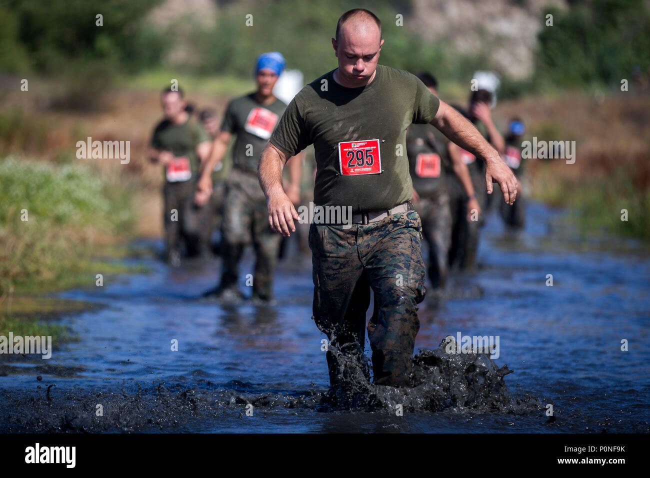 Marines trudge through the, “Chosin Reservoir” portion of the 2018 Mud Run Commanding General’s Cup Team Competition, on Marine Corps Base Camp Pendleton, Calif., June 8, 2018. The race stretched over 10-kilometers around Lake O’Neill on MCB Camp Pendleton. Over 2,000 Marines from numerous units around California and neighboring states participated in the challenge. (U.S. Marine Corps photo by Cpl. Juan C. Bustos) Stock Photo