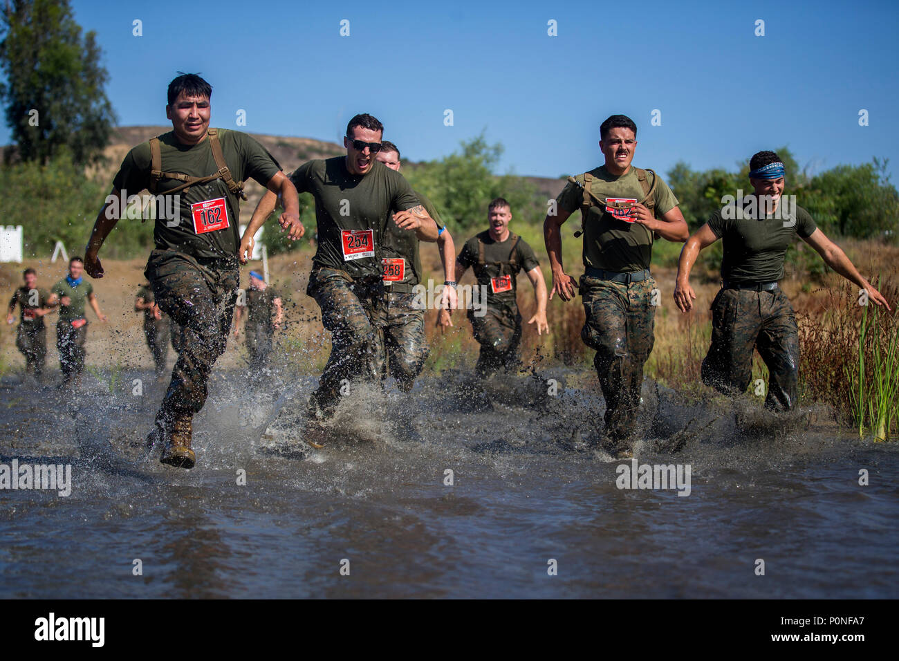 Marines run through the,“Chosin Reservoir”portion of the 2018 Mud Run Commanding General’s Cup Team Competition, on Marine Corps Base Camp Pendleton, Calif., June 8, 2018. The race stretched over 10-kilometers around Lake O’Neill on MCB Camp Pendleton. Over 2,000 Marines from numerous units around California and neighboring states participated in the challenge. (U.S. Marine Corps photo by Cpl. Juan C. Bustos) Stock Photo