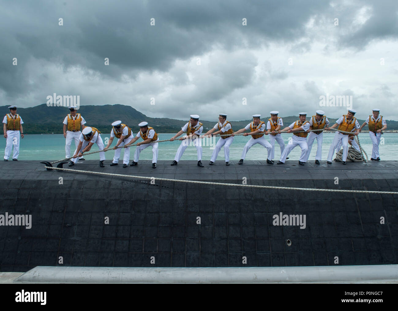 180607-N-WI626-011  APRA HARBOR, Guam (June 7, 2018) Sailors assigned to the Japan Maritime Self-Defense Force submarine JS Soryu (SS-501) heave a mooring line as the boat arrives in Guam for a port visit. (U.S. Navy photo by Lieutenant Lauren Spaziano/Released) Stock Photo