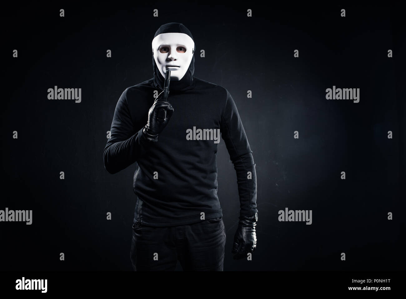Robber in mask and balaclava holding gun Stock Photo Alamy