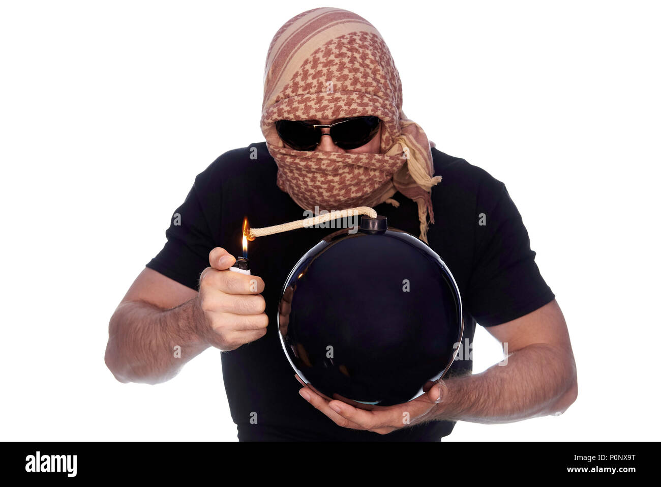 A man hidden under the arafatka and black glasses ignites a bomb on a white background. The concept of terrorism. Stock Photo