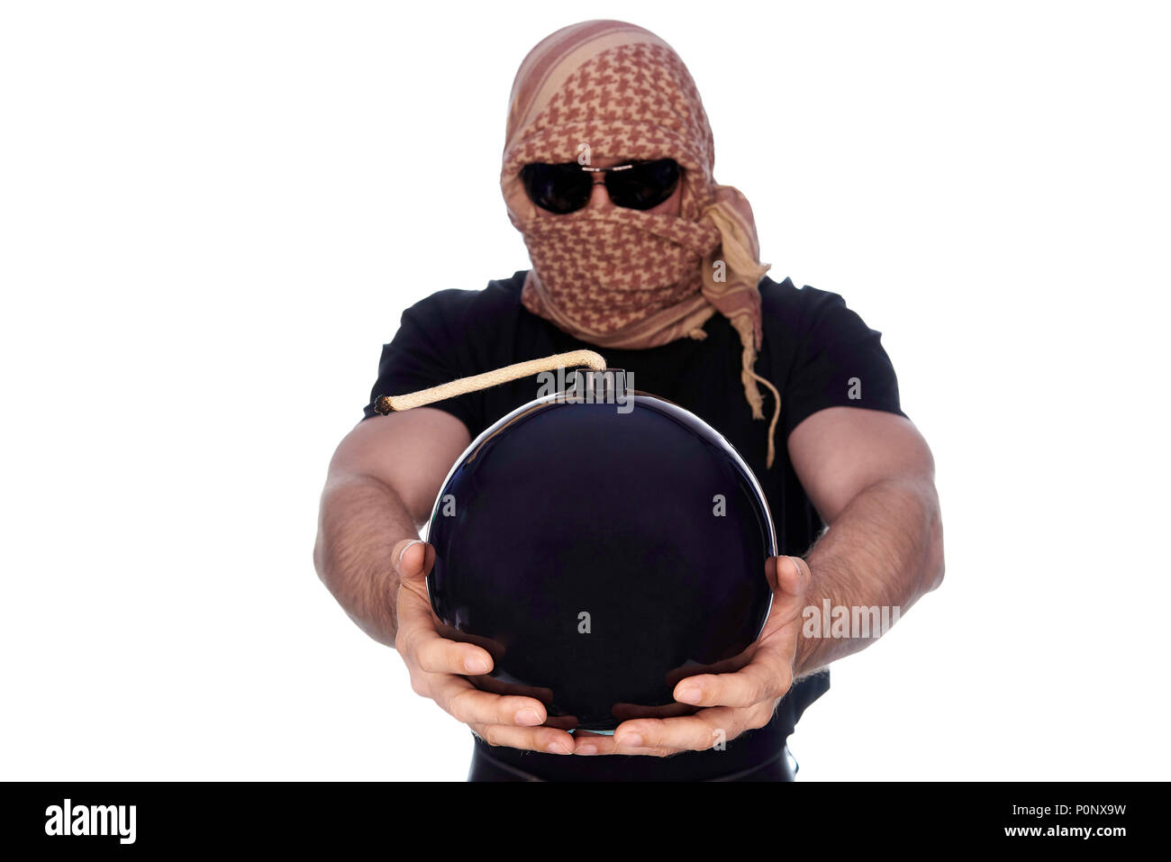 A lighted bomb in the outstretched hands of a young man hidden under a arafatka and black glasses on a white background. Stock Photo