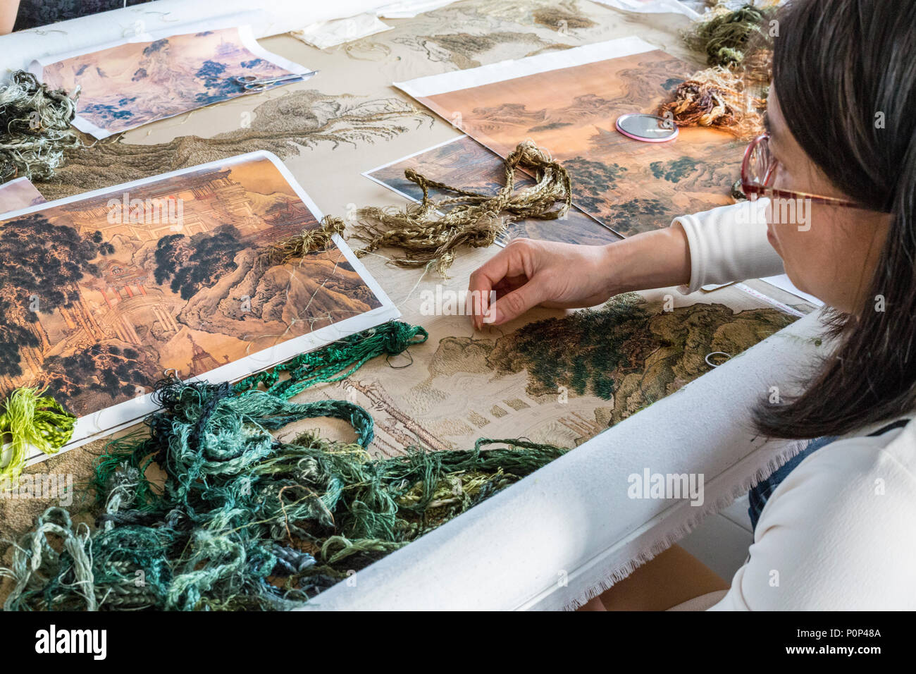 Suzhou, Jiangsu, China.  Young Woman Working on a Piece of Embroidery Art. Stock Photo