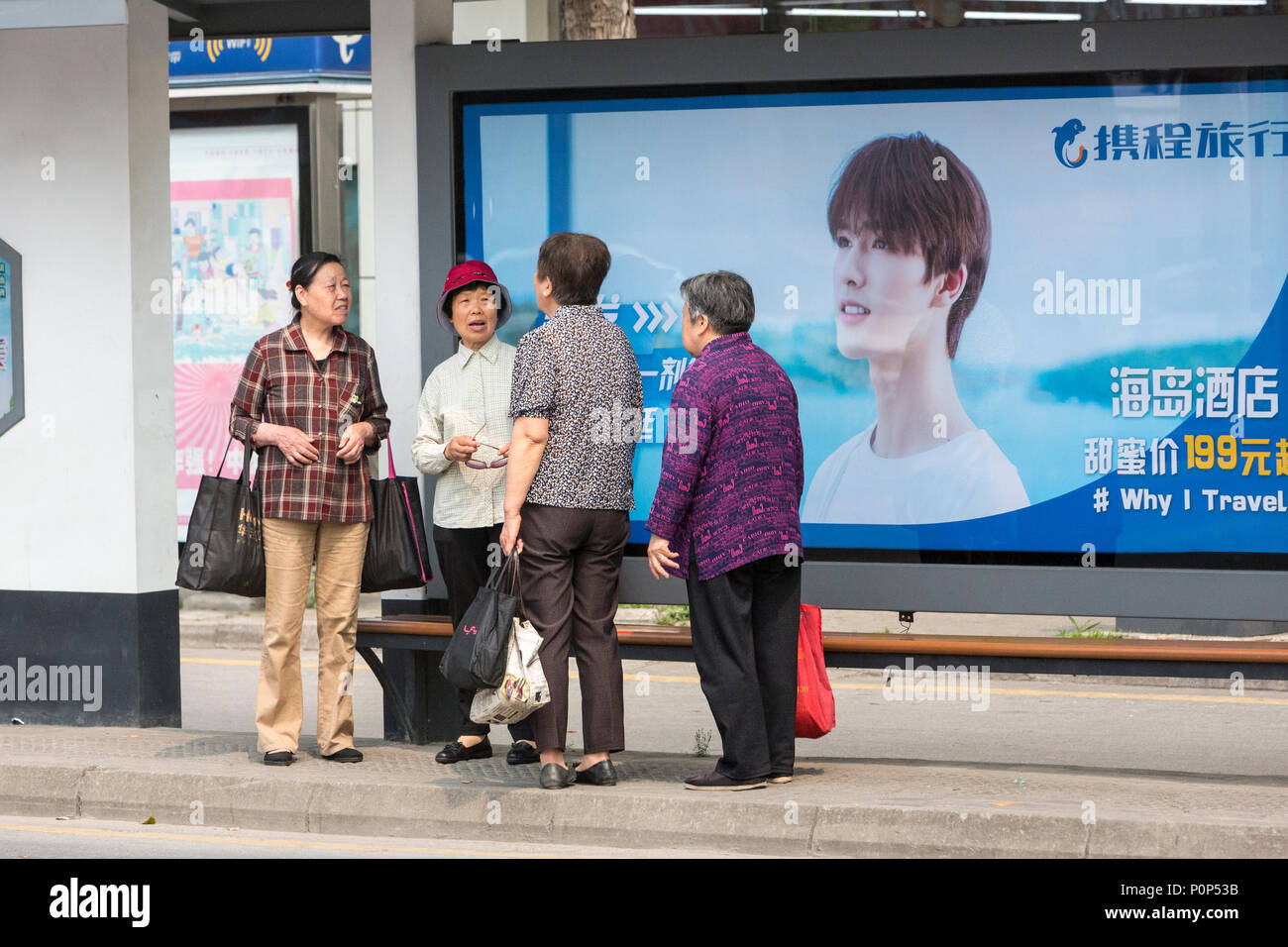Suzhou, Jiangsu, China.  Middle-aged Women Waiting at a Bus Stop. Stock Photo