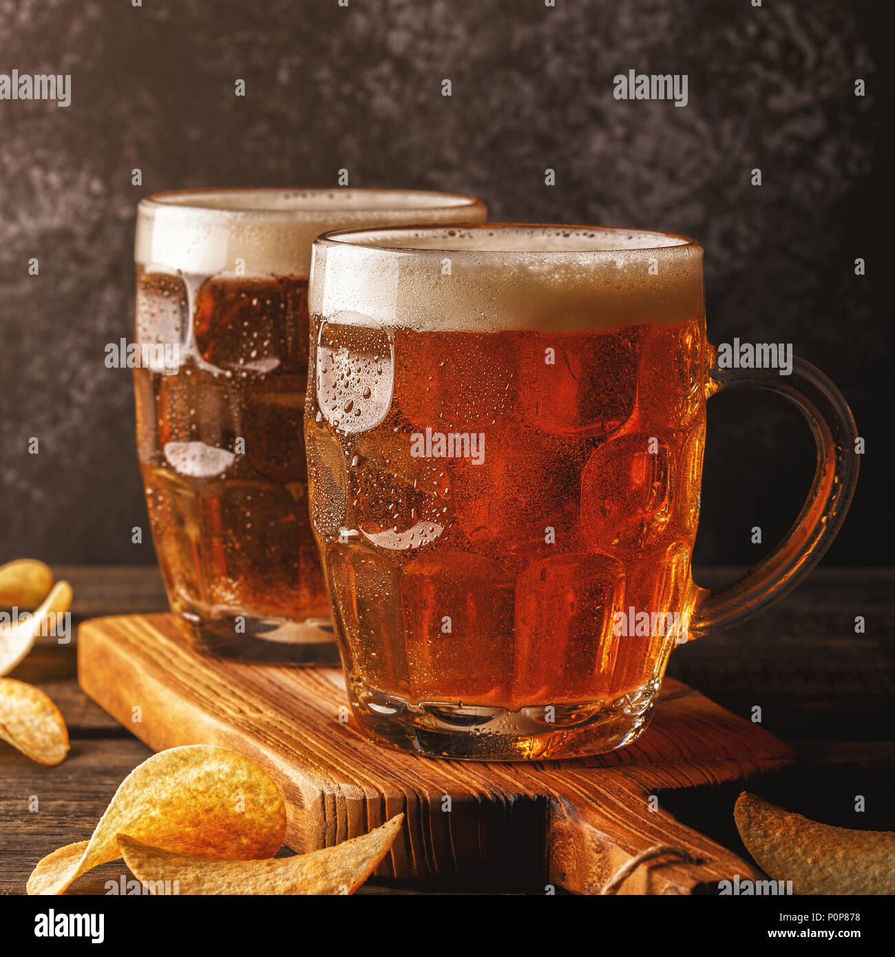 https://c8.alamy.com/comp/P0P878/beer-cold-beer-in-glass-with-chips-on-a-dark-background-P0P878.jpg