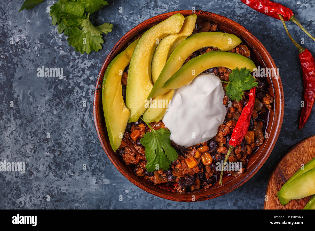 Chili con carne in bowl with avocado and sour cream, top view Stock Photo -  Alamy