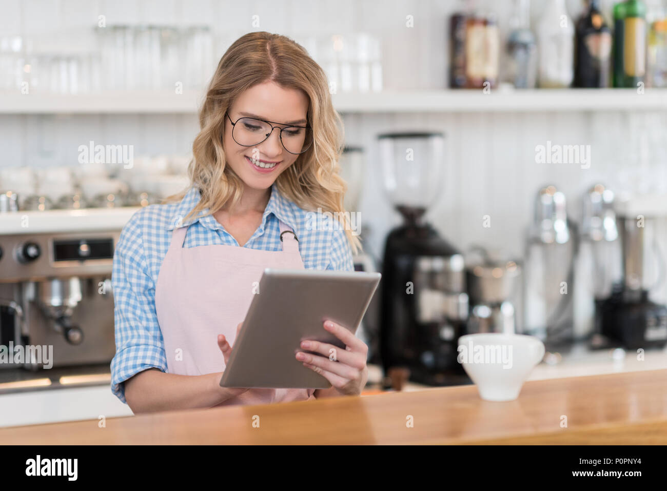 young waitress using digital tablet during work in coffee shop Stock Photo