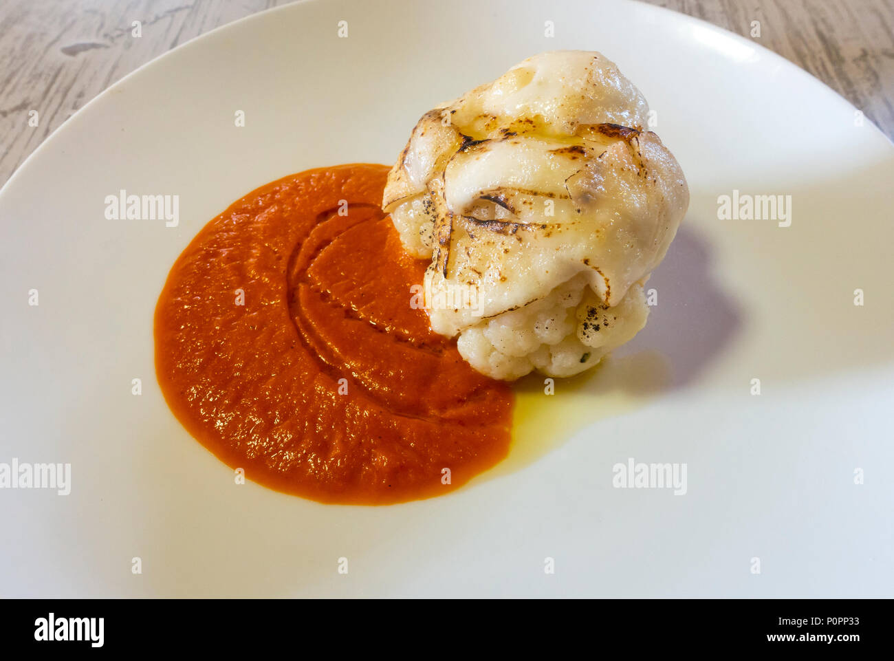 Cauliflower with cheese in a spicy red sauce Stock Photo