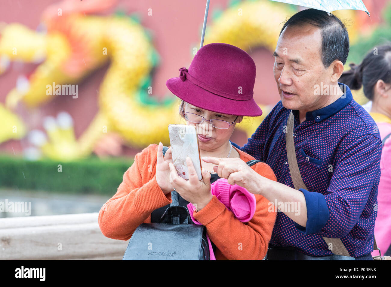 Nanjing, Jiangsu, China.  Middle-aged Chinese Couple Taking a Photo. Stock Photo