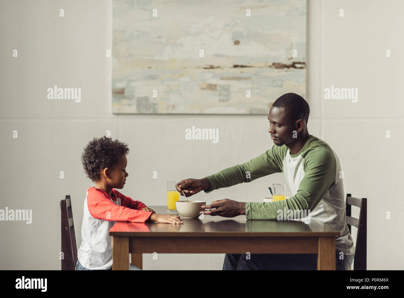 side view of african american father and son eating breakfast Stock ...