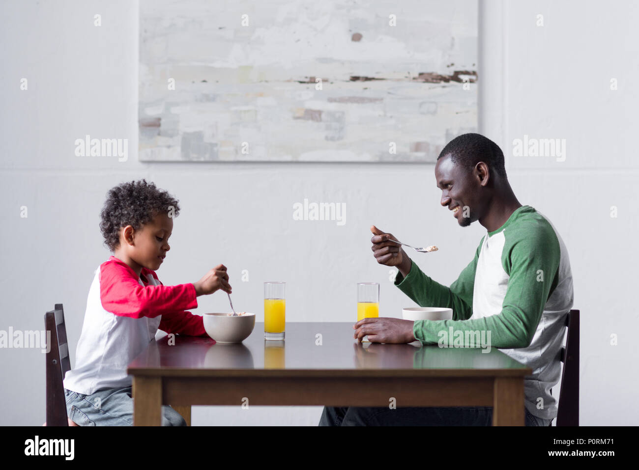 side view of african-american father and son eating breakfast Stock ...